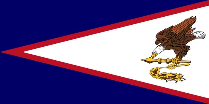 The flag of American Samoa features a white triangle pointing toward the fly side, bordered in red and set against a dark blue field. Inside the triangle, a bald eagle clutches a Samoan war club and fly-whisk, symbolizing both American authority and Samoan cultural heritage.