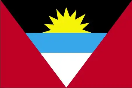 The flag features an inverted isosceles triangle with a rising sun in the top section, set against red, black, blue, and white bands. It represents the dawn of a new era following independence.