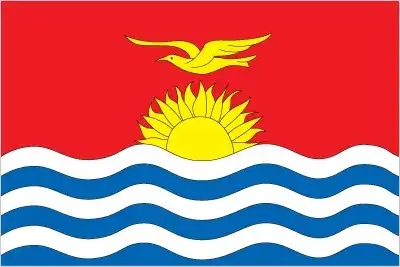 Kiribati Flag - The flag of Kiribati presents a red upper half with a golden frigate bird flying over a rising sun of seventeen rays, above a lower blue half with three white w