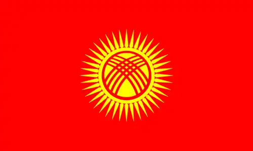 National flag of Kyrgyzstan - The flag of Kyrgyzstan features a deep red field charged in the center with a stylized golden sun made of forty evenly spaced rays encompassing a red circular ‘tunduk’ (roof crown of a traditional yurt), viewed from below. This unique composition evokes Kyrgyzstan’s nomadic heritage, unity, and cultural identity.