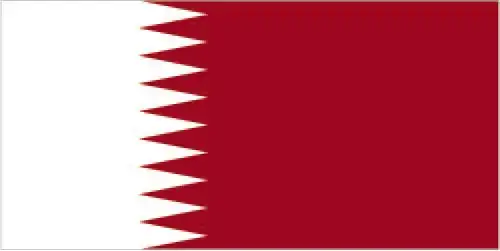 National flag of Qatar - Qatar’s flag features a narrow white band at the hoist separated by nine serrated points from a wide maroon field. It has the world’s longest flag ratio and is visually distinctive in both shape and color.